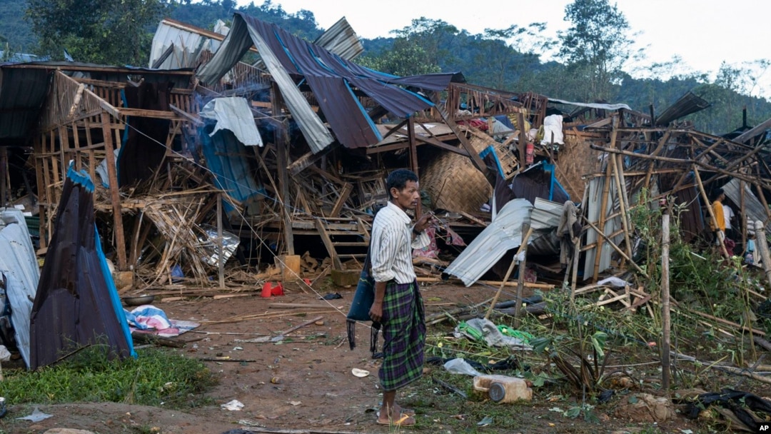 FILE - A man looks on at homes destroyed after air and artillery strikes in Mung Lai Hkyet displacement camp, in Laiza, Myanmar, on Oct. 10, 2023.