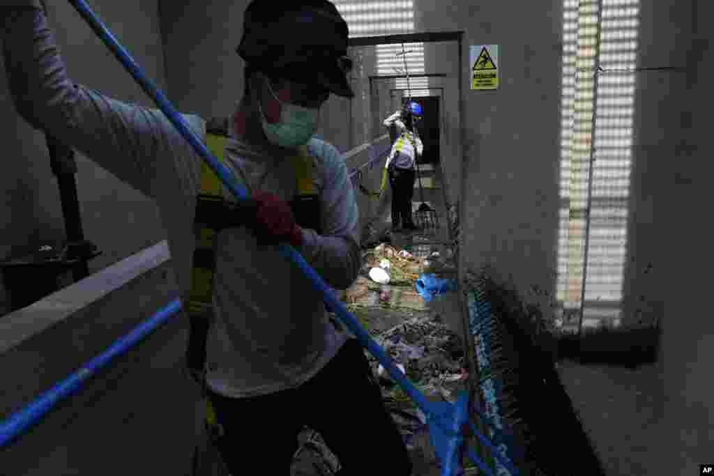 Operarios de tratamiento de aguas limpian basura dentro de la planta de Sedapal, en Lima, Perú.