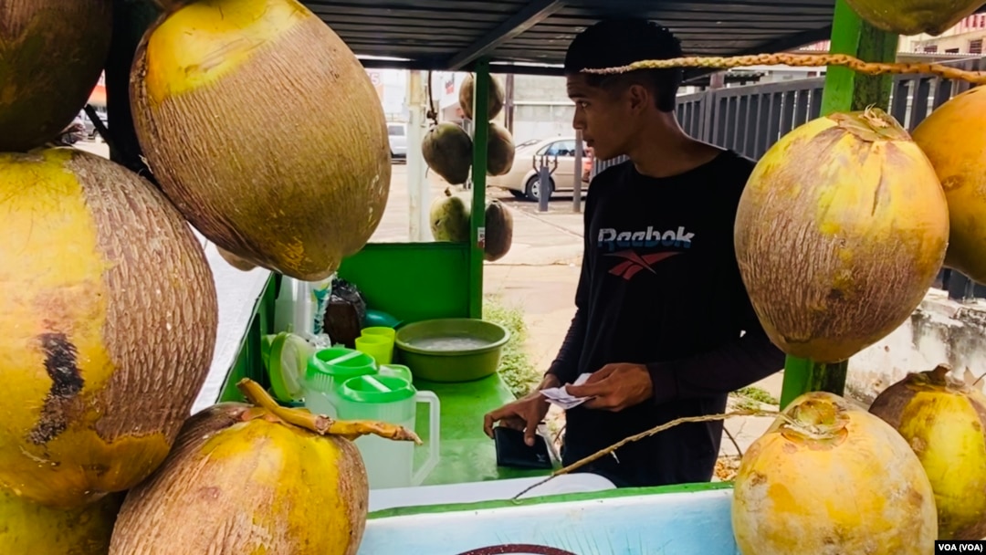 Andry Araque, vendedor de cocos, repasa sus ganancias en bolívares y dólares la mañana de este miércoles, en Maracaibo, Venezuela.