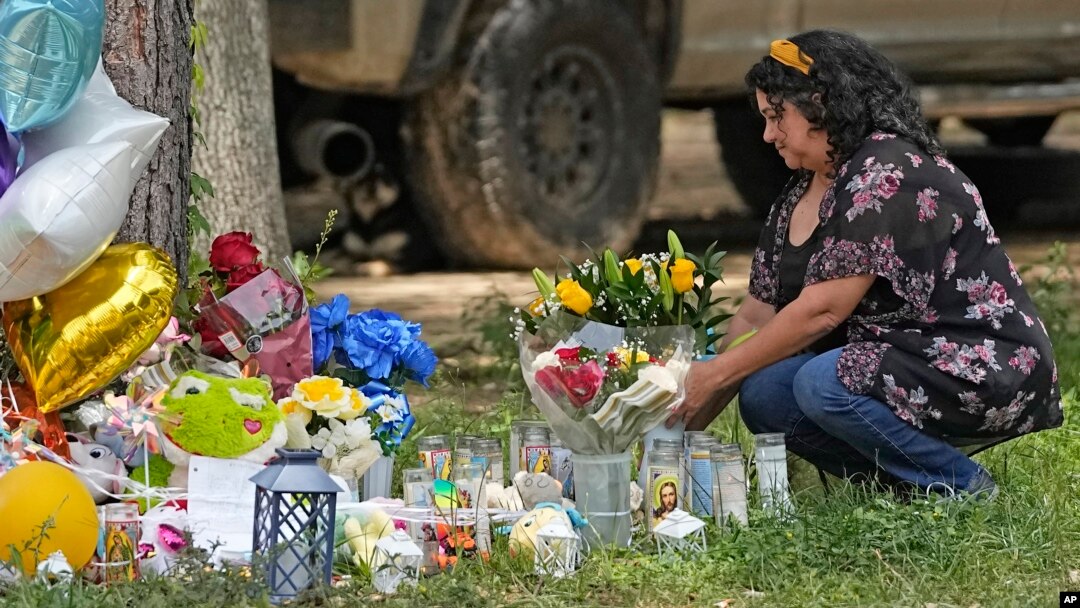 Maria Rodriguez places flowers outside the location of Friday's mass shooting in Cleveland, Texas, May 2, 2023. After a four-day manhunt, police have arrested a suspect.