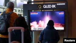 资料照片：2023年3月16日，人们在韩国首尔的一个火车站观看电视新闻中播放有关朝鲜向其东海岸海域发射弹道导弹的报道。（路透社照片）