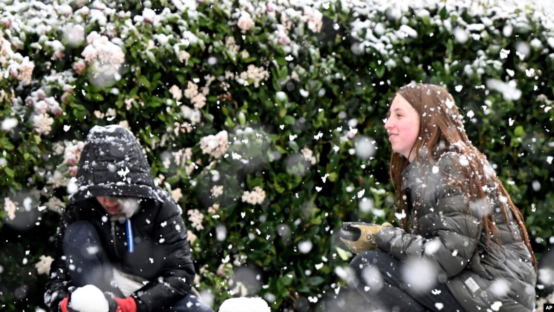 Brody Mielke, left, 10, and his older sister Braelynn, 12, make a snowman as snow falls at approximately the 1,700 foot level in front of their Fontana, Calif., home in Hunters Ridge, Feb. 25, 2023. (Will Lester/The Orange County Register via AP)
