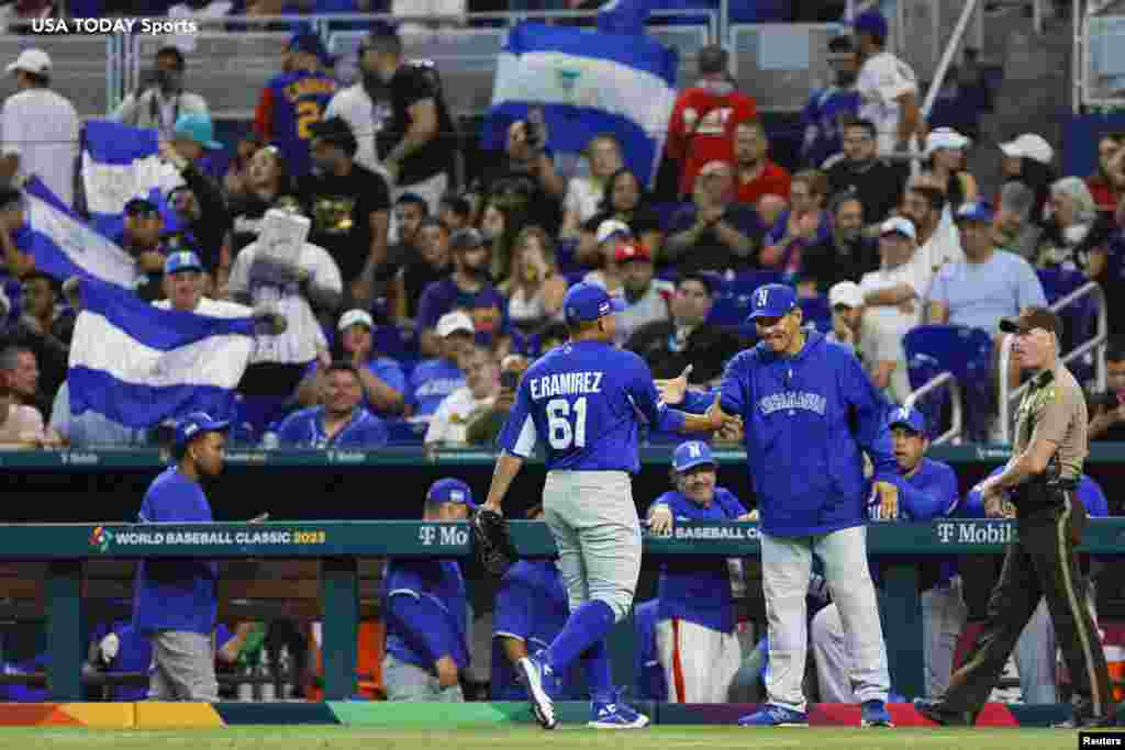 El lanzador abridor de Nicaragua Erasmo Ramírez (61) celebra con el entrenador de pitcheo Cairo Murillo (4) en la cuarta entrada contra Venezuela.&nbsp;
