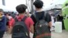 Dos jóvenes de ascendencia cubana caminan por un centro de distribución de útiles escolares en la ciudad de Hialeah, en Florida, EEUU.