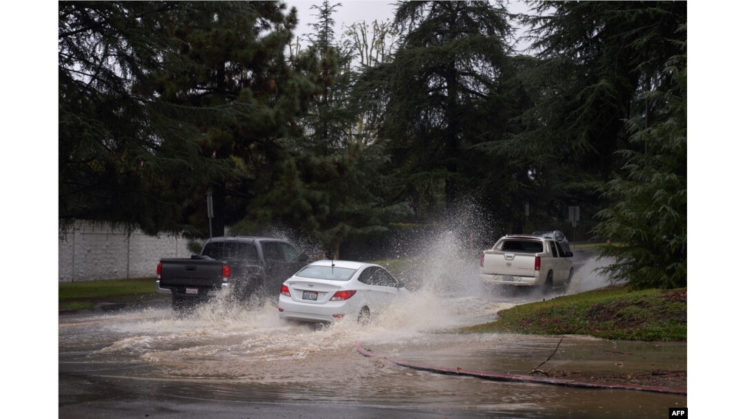 Vehicles drive down a flooded roadway due to severe rain in Los Angeles, California, on Feb. 25, 2023.