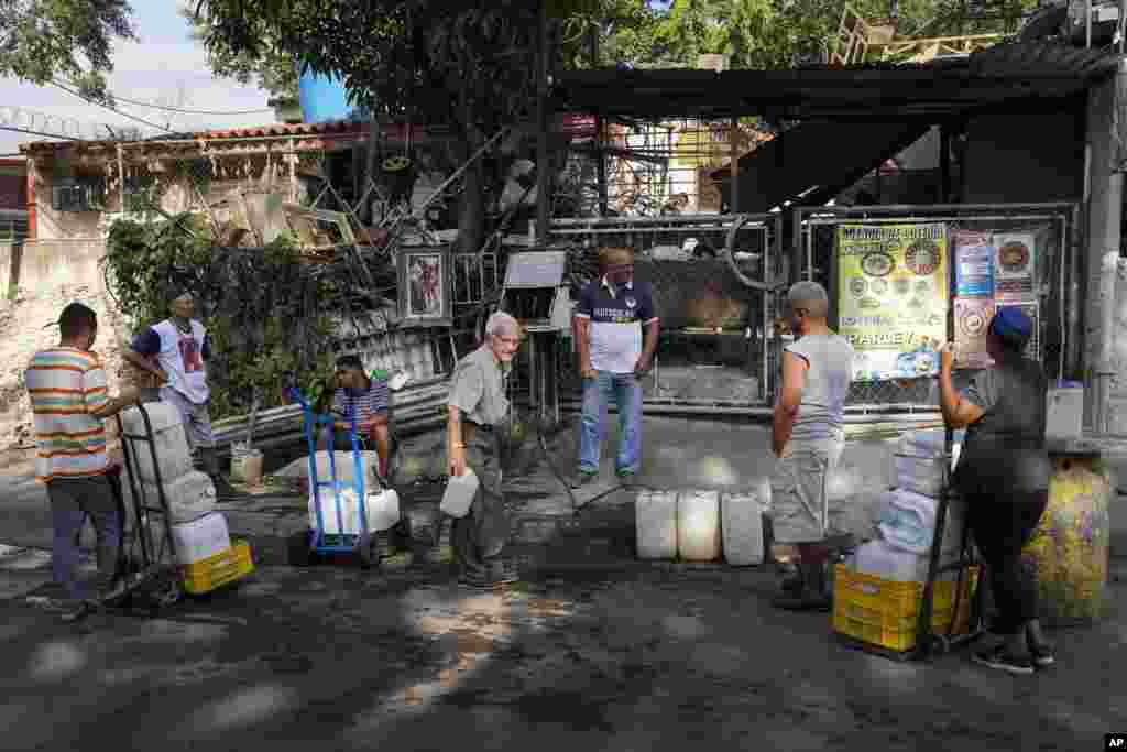 Habitantes del barrio Cotiza, en Caracas, hacen fila mientras llega su turno de llenar los recipientes del agua que recolectan en un túnel de autopista abandonado.&nbsp;