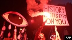 2023 年 4 月 29 日，示威者在集會期間舉起標語牌並使用照明彈，抗議以色列政府在特拉維夫的司法改革法案。
