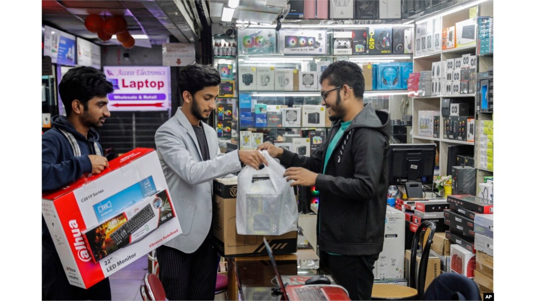 FILE - Customers buy computers and other digital accessories at a computer market in Dhaka, Bangladesh, Jan. 1, 2024. Recent high inflation has seriously slowed demand and consumption in the country.