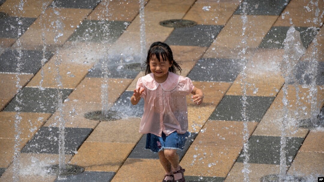 在一個酷熱的夏日，一個小女孩在北京一家商場外的噴水池裡嘻戲。（2022年6月25日）