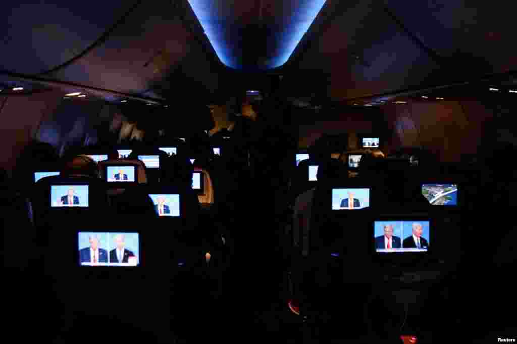People watch the U.S. presidential debate aboard a Delta Airlines flight to Miami, Florida, on June 27, 2024. 