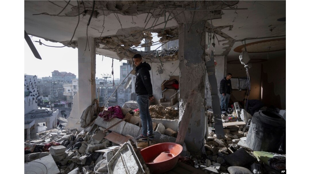 Palestinians look at a damaged residential building after an Israeli strike in Rafah, southern Gaza Strip, Jan. 10, 2024.