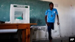 ARCHIVO - Un trabajador electoral discapacitado espera para emitir su voto justo después de la apertura de su colegio electoral durante las elecciones generales en Puerto Príncipe, Haití, el domingo 28 de noviembre de 2010.