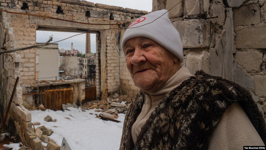 Lida, de 85 años, de pie en su apartamento del quinto piso que fue bombardeado y luego destruido por el fuego, fotografiada el 1 de abril de 2023 en Lyman, Ucrania. [Foto: Yan Boechat, VOA]