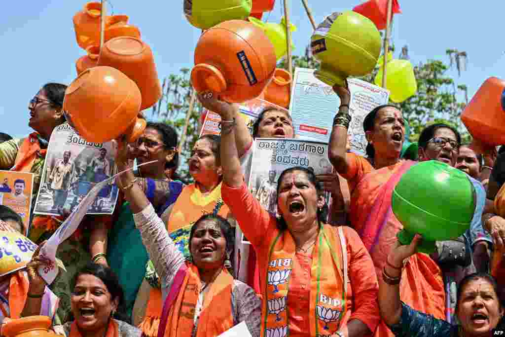 Activists and members of the Bharatiya Janata Party (BJP) hold empty water pots as they shout slogans during a protest against the state government over ongoing severe water crisis, in Bengaluru, India.