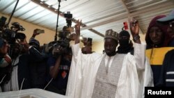 O candidato presidencial Bassirou Diomaye Faye, apoiado pelo líder da oposição senegalesa Ousmane Sonko, gesticula depois de votar na assembleia de voto de Ndiaganiao, em Mbour, Senegal, a 24 de março de 2024