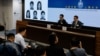 香港当局在记者会上公布被通缉的五名活动人士的照片。（2023年12月14日）