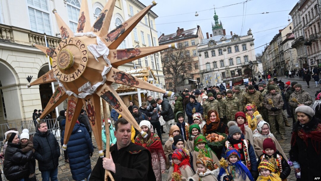 Civilians and soldiers walk through a street as they take part in Christmas Eve procession in Lviv, western Ukraine, Dec. 24, 2023, amid Russia's ongoing invasion of its neighbor.