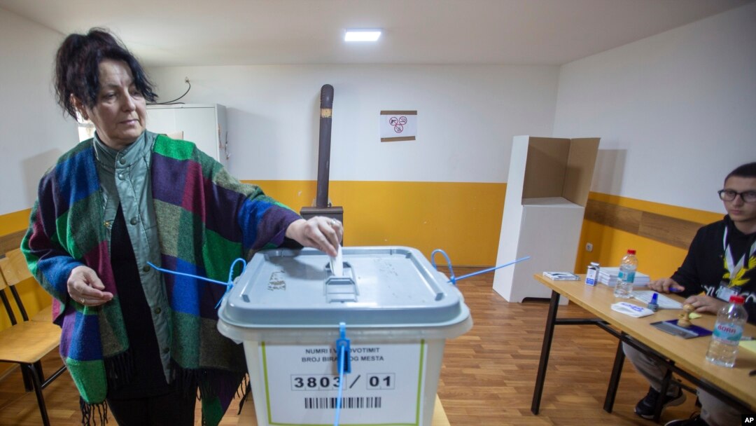 A woman casts her ballot at a polling station in the northern Serb-dominated part of ethnically divided town of Mitrovica, Kosovo, April 21, 2024. 