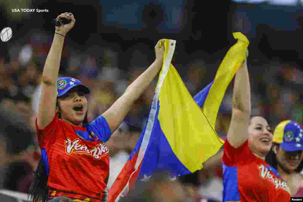 Fanáticas animan a Venezuela mientras ondean una bandera durante el juego contra Nicaragua.