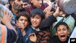 Palestinians line up for food in Rafah, Gaza Strip, Nov. 30, 2023, during a temporary ceasefire between Israel and Hamas.