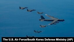 A U.S. Air Force B-52H bomber, center, F-16 fighter jets, South Korean Air Force F-15K fighter jets, left top, and Japanese Air Force F-2 fighter jets, left bottom, fly in formation during a joint air drill near Korean Peninsula, Oct. 22, 2023. 