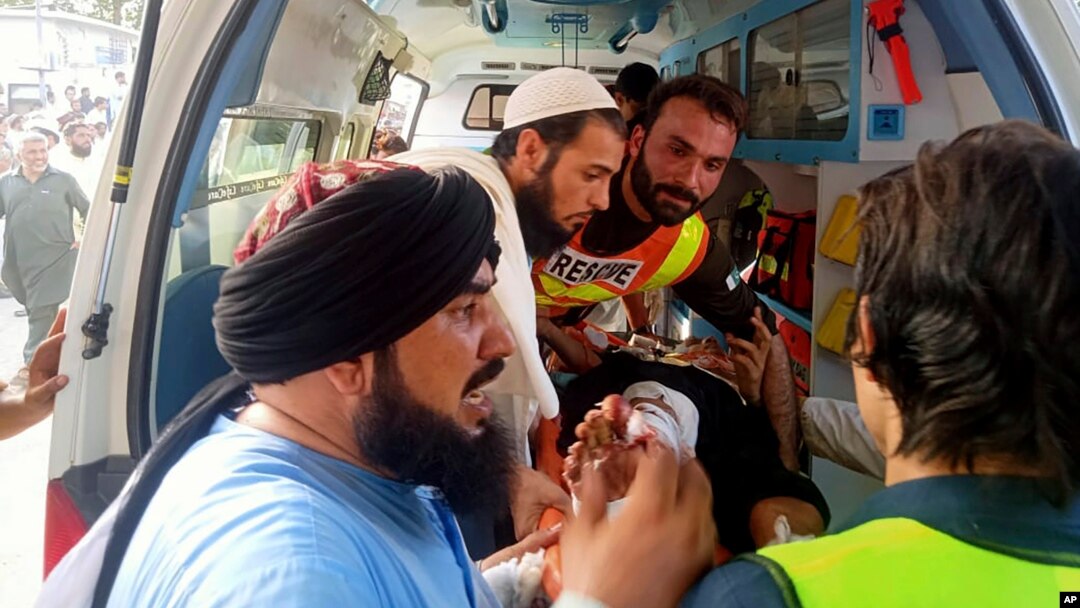 First responders move a wounded man into an ambulance after a bomb explosion in the Bajaur district of Khyber Pakhtunkhwa, Pakistan, July 30, 2023. (Rescue 1122 Headquarters via AP)