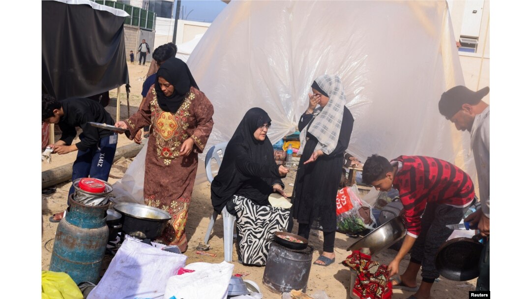 Displaced Palestinians, who fled their houses due to Israeli strikes, prepare to bake bread next to a tent, at a camp in Rafah in the southern Gaza Strip, Dec. 10, 2023.