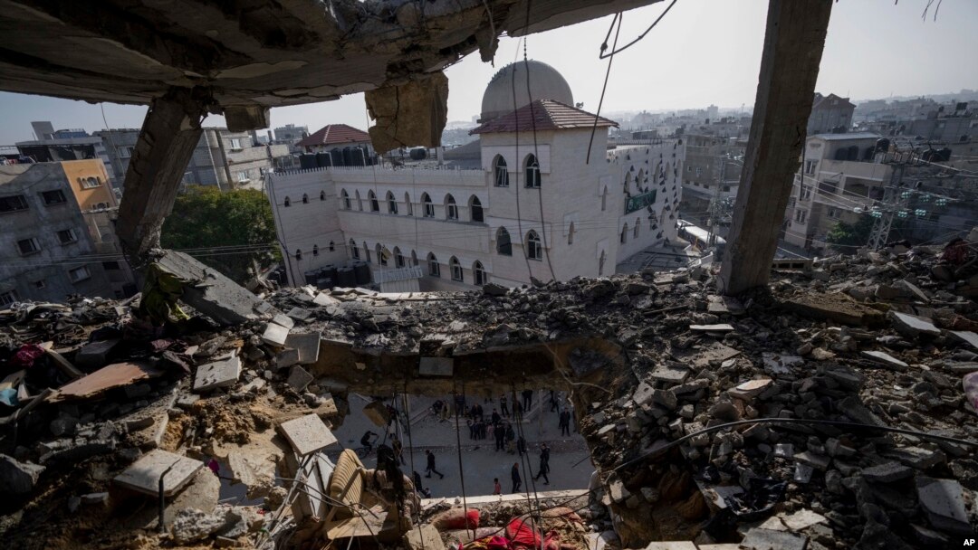 Palestinians look at a damaged residential building after an Israeli strike in Rafah, southern Gaza Strip, Jan. 10, 2024. 
