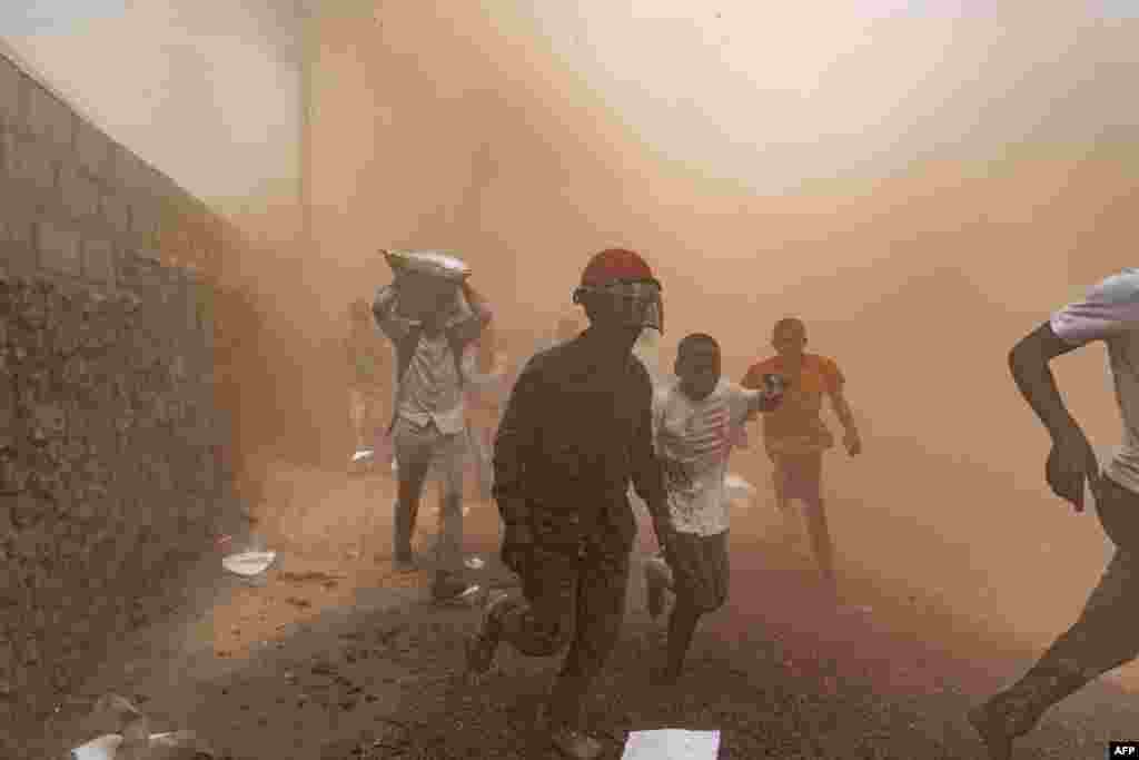 Looters flee from a warehouse belonging to the peacekeeping mission in the Democratic Republic of Congo (MONUSCO) at the U.N. facilities in Goma, July 25, 2022. Protesters stormed a United Nations base in the eastern city of Goma, an AFP journalist said, demanding the departure of peacekeepers from the region. 