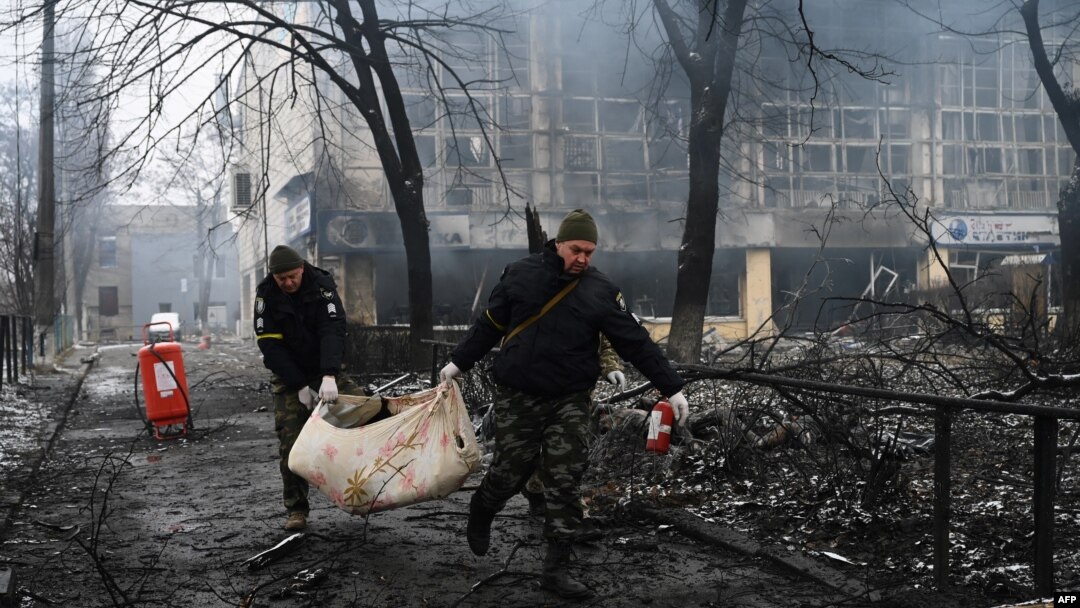 Police officers remove the body of a person killed in a March 1, 2022, airstrike that hit Kyiv's main television tower, March 2, 2022.