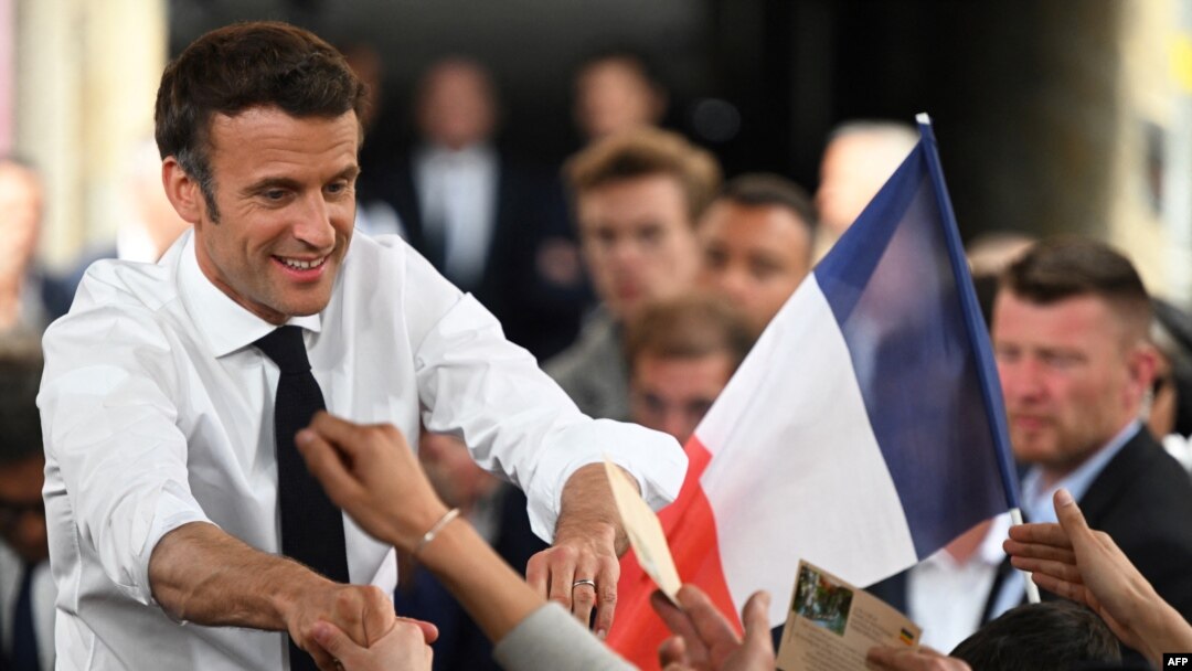 El presidente francés y candidato a la reelección del partido centrista La Republique en Marche (LREM), Emmanuel Macron, estrecha la mano de sus partidarios en un mitin el último día de campaña, en Figeac, sur de Francia, el 22 de abril de 2022.