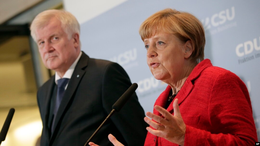 FILE - German Chancellor Angela Merkel, right, and the Governor of the German State of Bavaria, Horst Seehofer, left, address the media during a statement about their talks on the migrant influx in Berlin, Germany, Nov. 3, 2015. 