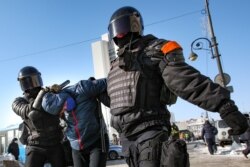 Police officers detain a man during a protest against the jailing of opposition leader Alexei Navalny in Vladivostok, Russia, on Sunday, Jan. 31, 2021.