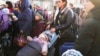 Refugees with children wait for a transport after fleeing the war from neighboring Ukraine at a railway station in Przemysl, Poland, March 24, 2022.