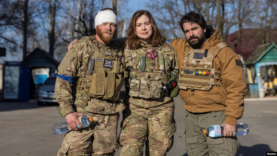 FILE - Members of a group of U.S. volunteer fighters who have taken up arms alongside Ukrainian soldiers, stand in front of a hospital in the town of Brovary, near Kyiv, amid Russia's invasion of Ukraine, March 20, 2022.
