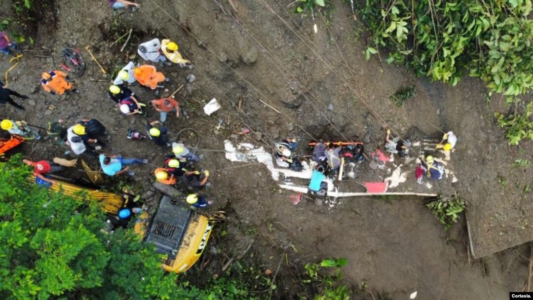 Un grupo de socorristas y voluntarios trabajan para sacar de la tierra los cuerpos de las personas que continúan dentro de un autobús arrastrado por un deslave en Colombia el 5 de diciembre de 2022. Foto cortesía del Ministerio de Defensa de Colombia. 