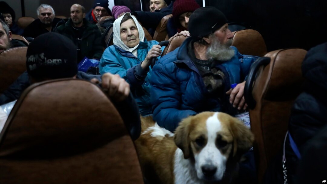 People from Soledar sit inside a bus as they wait to be registered and take up temporary accommodation somewhere near Shakhtarsk, in Russian-controlled Donetsk region, eastern Ukraine, Jan. 13, 2023.