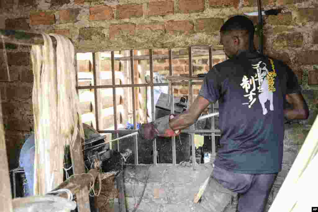 Employee Anathole Kisakye, employee, extracts banana fiber threads using a machine Tupande Holdings Ltd workshop, in Kiwenda village, Busukuma, Wakiso District. Uganda, Sept. 20, 2023. 