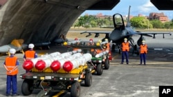 台湾军队士兵站在F16V战机前,准备进行装载美制AGM-84鱼叉反舰导弹、AIM-120和AIM-9空空导弹的训练。(2022年9月16日)