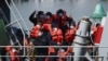 FILE - Migrants prepare to disembark from a UK Border Force boat at the port of Dover, having been picked up crossing the English Channel from France on April 15, 2022, at Dover, England.