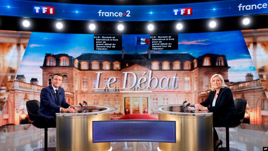 Centrist candidate and French President Emmanuel Macron, left, and far-right contender Marine Le Pen pose before a televised debate outside Paris on April 20, 2022. 