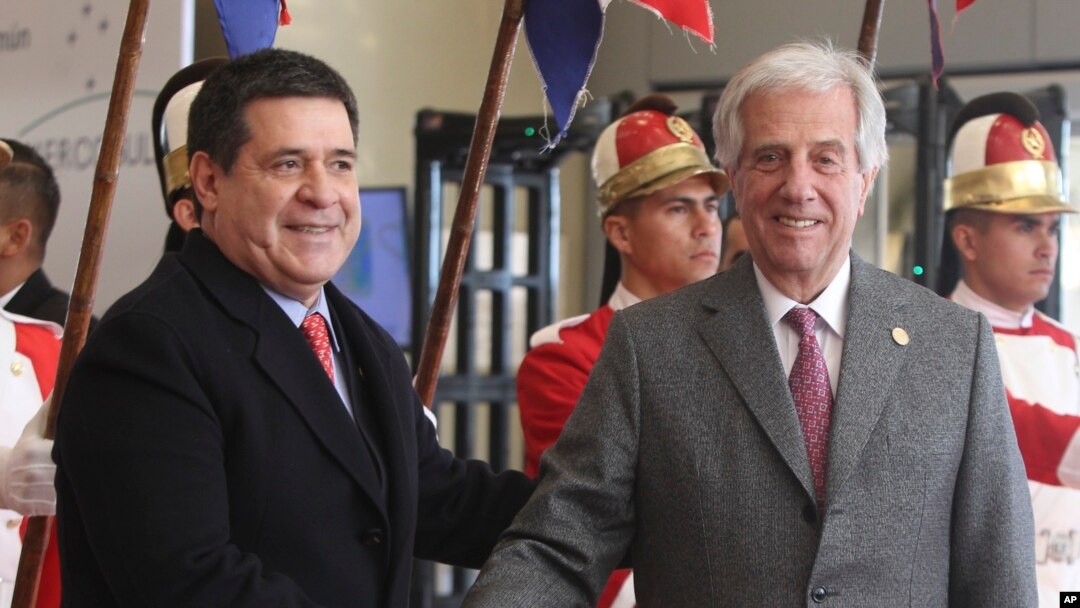 FILE - Paraguay's outgoing President Horacio Cartes receives Uruguay's President Tabare Vazquez, at the 52nd Mercosur Summit in Luque, Paraguay, June 18, 2018.
