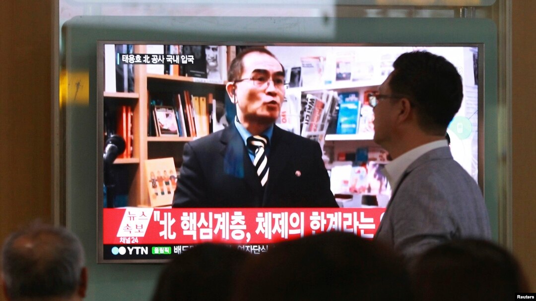 FILE - People watch a TV news program showing a file image of Thae Yong Ho, a high-profile North Korean defector, at Seoul Railway Station in Seoul, South Korea, Aug. 17, 2016