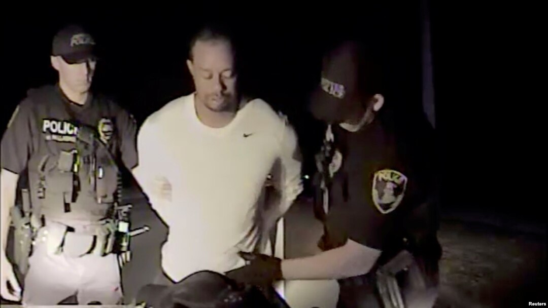 FILE - Tiger Woods is seen handcuffed and searched by police officers in this still image from police dashcam video in Jupiter, Florida, May 29, 2017.