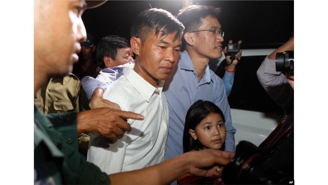 FILE - Two former Radio Free Asia reporters Uon Chhin, center, and Yeang Socheamet, right, hold together as they walk outside the main prison of Prey Sar at the outskirt of Phnom Penh, Cambodia, Aug. 21, 2018.
