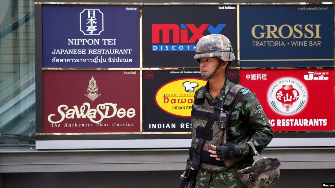 A soldier stands guard outside a shopping mall to stop protests against military rule at a shopping district in central Bangkok, June 1, 2014.
