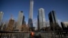 A cleaner walks on a pedestrian overpass against the skyscrapers under construction at the Central Business District in Beijing, Jan. 21, 2019. 