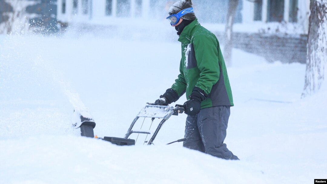 A man clears snow from his driveway following a winter storm that hit the Buffalo region in Amherst, New York, Dec. 25, 2022. 