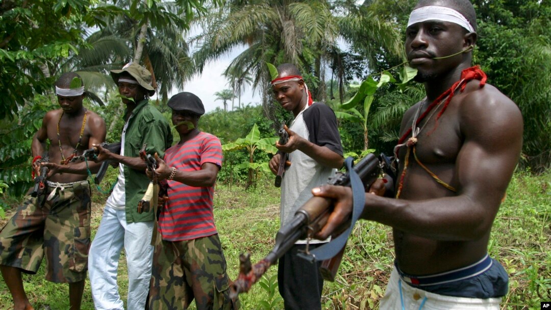 FILE- Militants stand guard at Okorota, near Port Harcourt, Nigeria. Nigeria's government resumed paying stipends to former militants in August 2016, even as security forces reported killing scores of fighters disrupting petroleum production in the oil-rich Niger Delta. 
