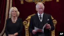 英国新国王查尔斯三世，坐在他身后右边的是卡米拉王后。（美联社照片）